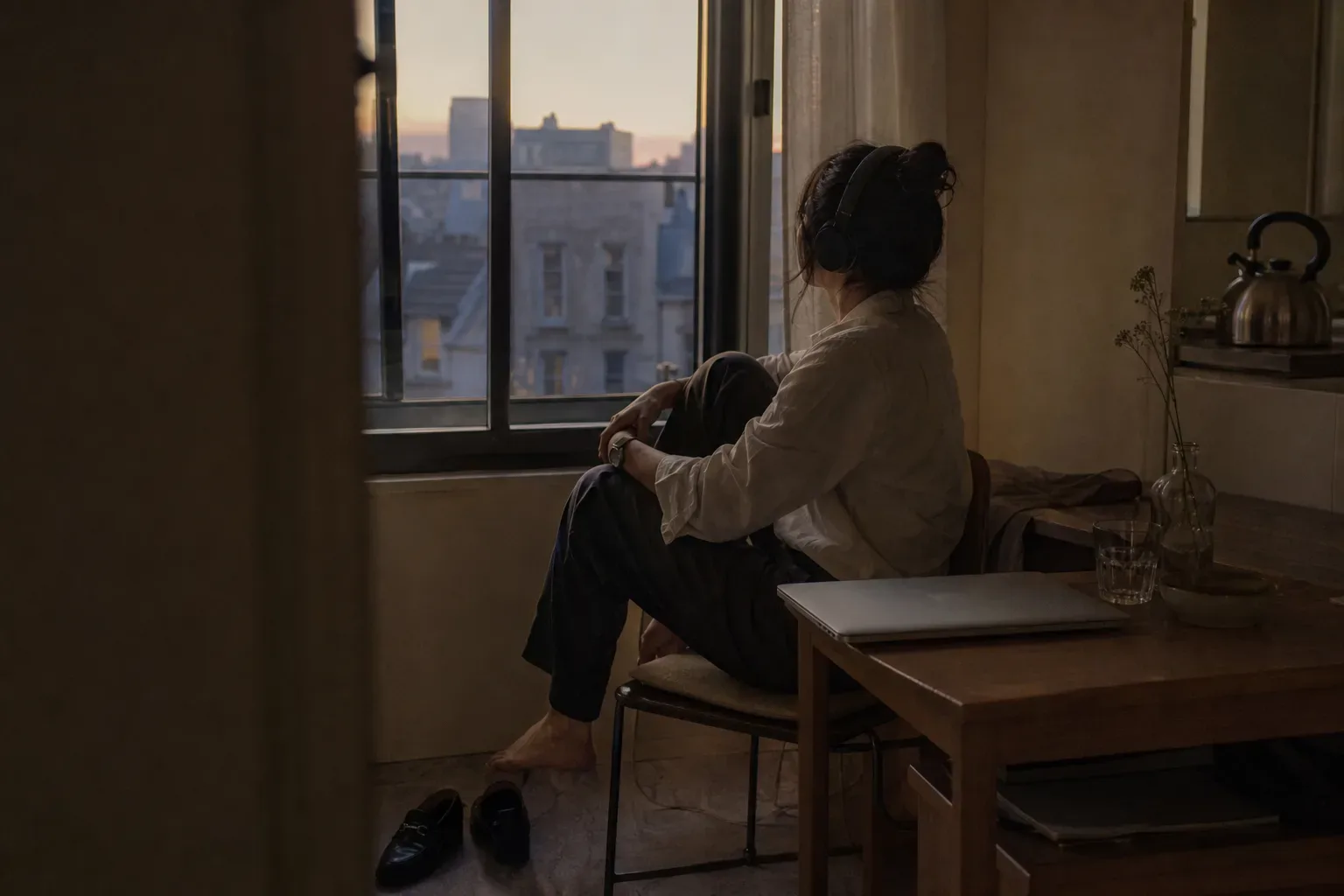 Person listening with headphones after work by window