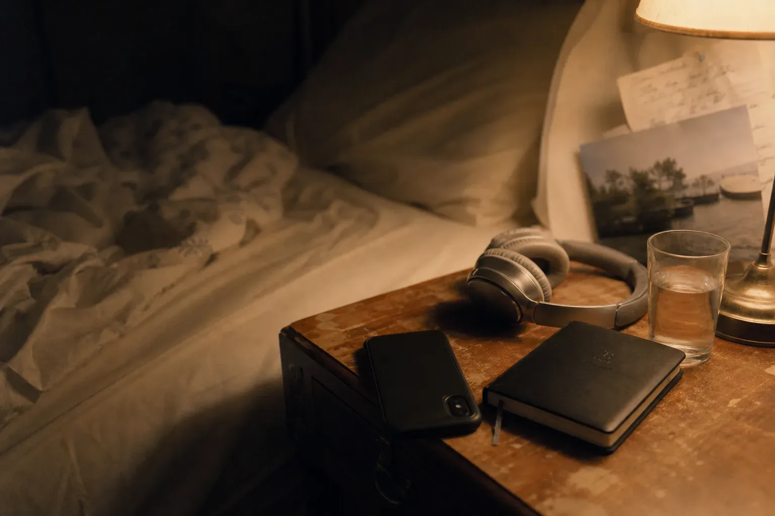 Audífonos junto a la cama al lado de un diario con luz suave